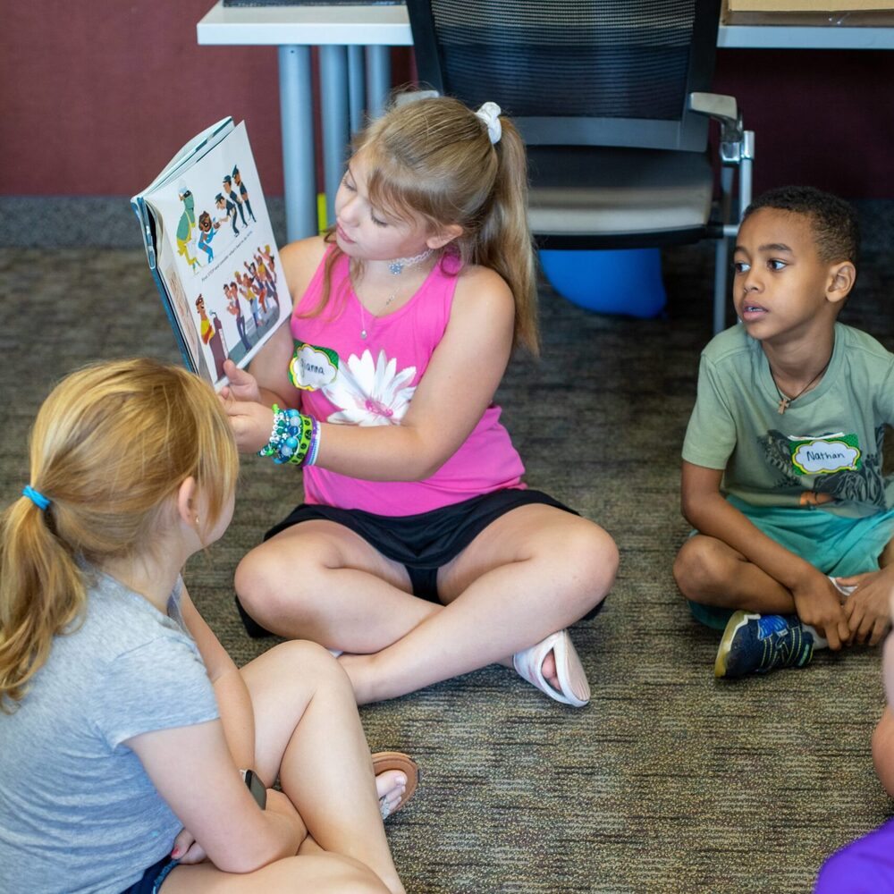 Young Student Reading to Other Summer Camp Kids During the BW Literacy Camp