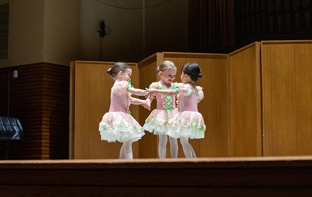 Three Young Dance Students Holding Hands in a Circle During Pre-Ballet and Tap Class
