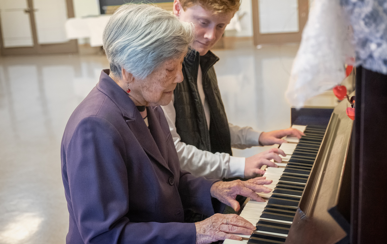 BW Piano Teacher Playing at a Piano with High School Student